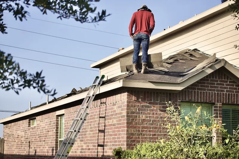 Professional roofer working on a residential roof in Egan